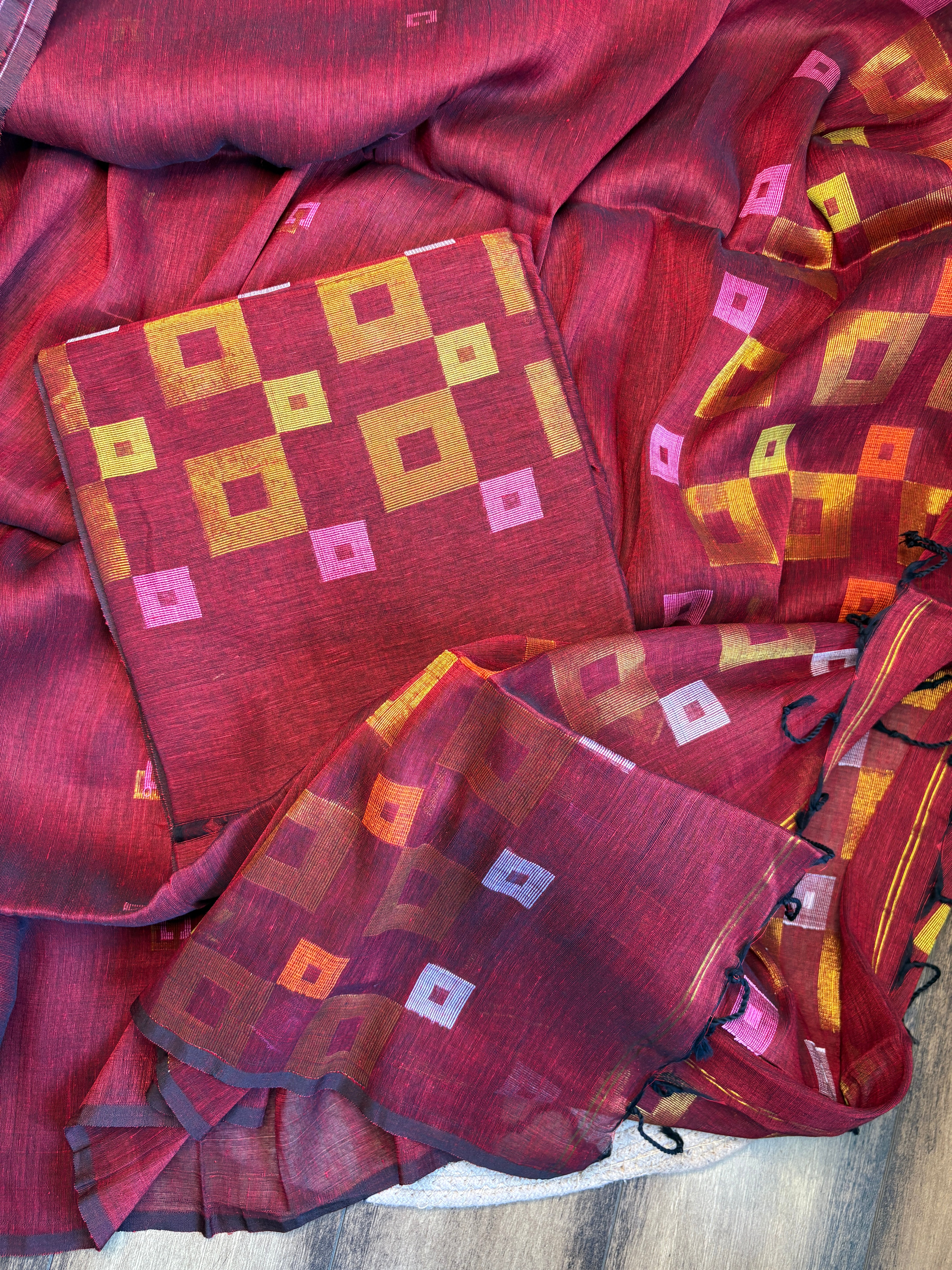 Close-up of handwoven geometric Jamdani motifs on red pure linen