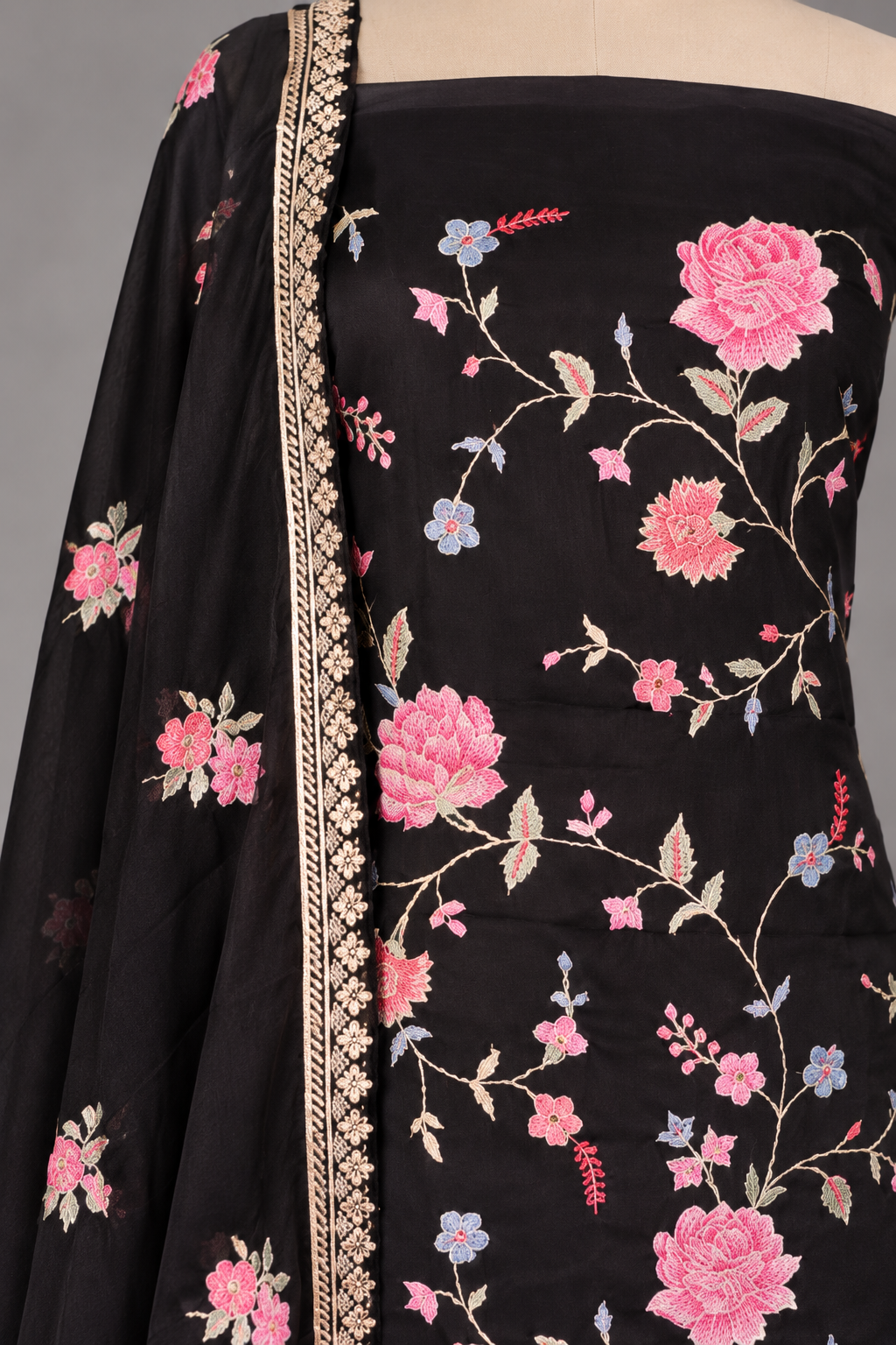 Close-up of cross stitch rose embroidery on black twill kurta with gold-bordered dupatta
