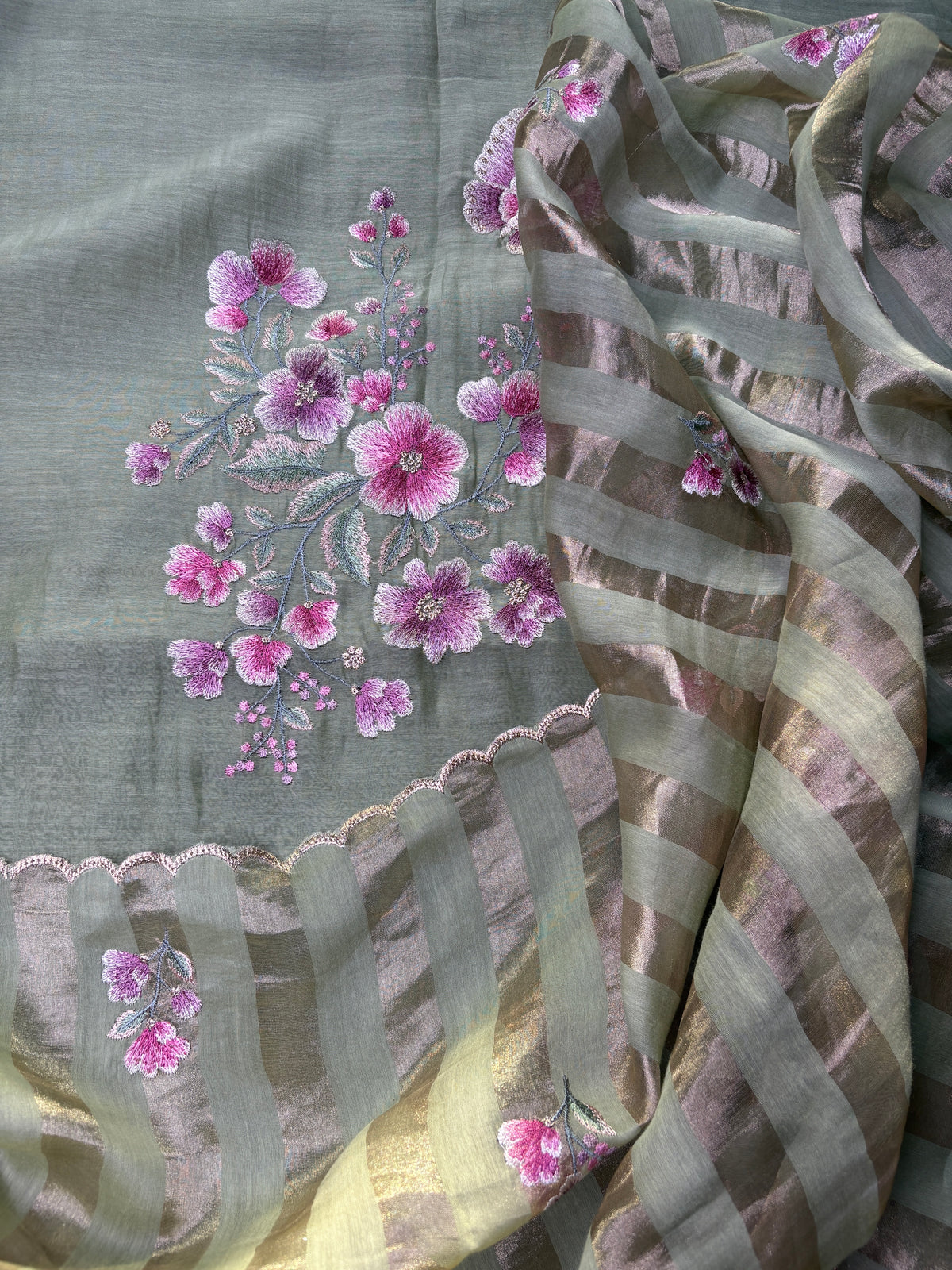 Detail of sage green mul cotton suit fabric and embroidery