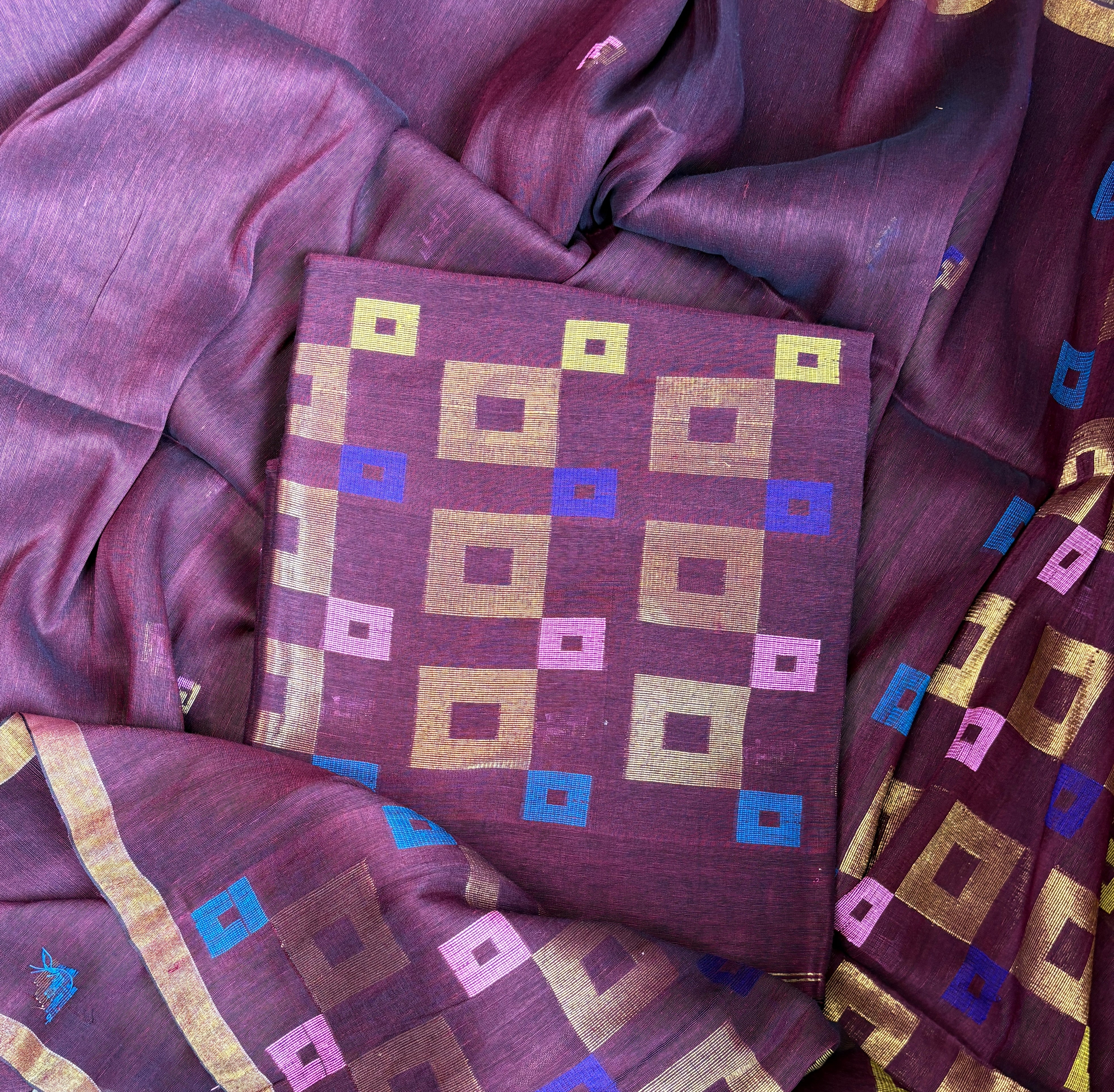 Close-up of handwoven geometric Jamdani motifs on deep burgundy pure linen