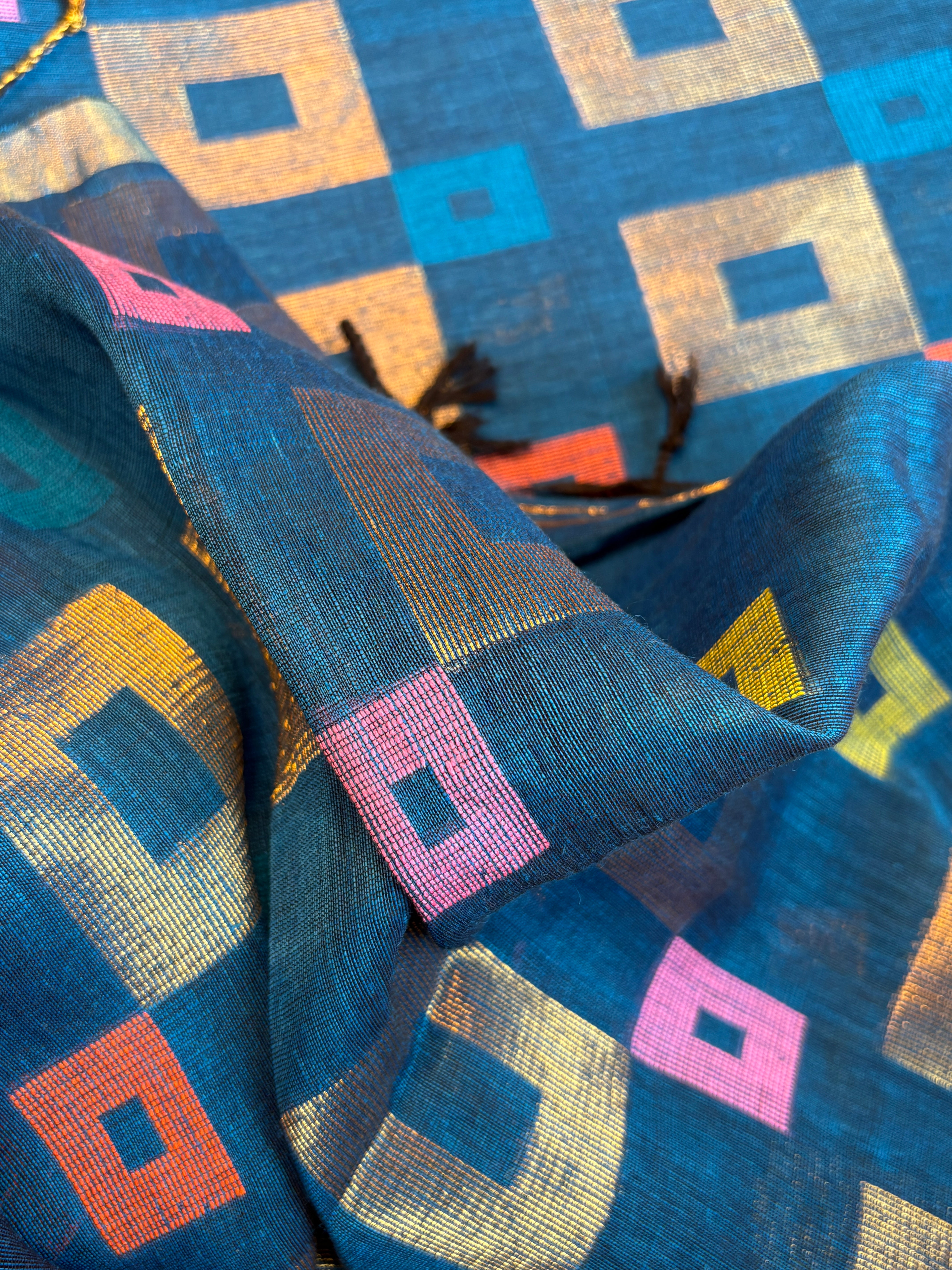 Close-up of handwoven geometric Jamdani motifs on peacock blue pure linen